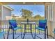 Screened-in patio with teal chairs and a glass-topped table, overlooking the neighborhood at 115 112Th Ne Ave # 310, St Petersburg, FL 33716