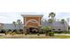 Inviting clubhouse entrance with stone accents and palm trees creating a welcoming atmosphere at 11521 Rose Tree Dr, New Port Richey, FL 34654
