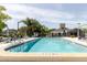 Large community pool with ample seating and shade, creating a perfect oasis for residents to relax and enjoy the sunshine at 11521 Rose Tree Dr, New Port Richey, FL 34654