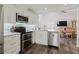 Modern kitchen with stainless steel appliances, tile backsplash, and open to dining area at 11521 Rose Tree Dr, New Port Richey, FL 34654