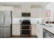 Modern kitchen featuring stainless steel appliances, tile backsplash, and white cabinets at 11521 Rose Tree Dr, New Port Richey, FL 34654