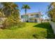 Charming two-story home featuring a spacious backyard and lush tropical landscaping at 118 Wall St, Redington Shores, FL 33708