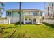 Inviting backyard featuring a spacious lawn and a two-story home with a private balcony at 118 Wall St, Redington Shores, FL 33708