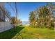 Beautiful lawn leading to the waterfront with mature trees and tropical vegetation at 118 Wall St, Redington Shores, FL 33708