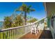 Cozy balcony features relaxing chairs, overlooking scenic water views and lush palms at 118 Wall St, Redington Shores, FL 33708