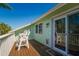 Inviting balcony features wood flooring and outdoor seating, accessible through sliding glass doors at 118 Wall St, Redington Shores, FL 33708