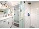 Well-lit bathroom with a glass shower, white subway tiles, a modern vanity, and a black framed mirror at 118 Wall St, Redington Shores, FL 33708