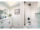 Bright bathroom featuring a white vanity with sleek, black hardware and a herringbone-patterned shower with a glass door at 118 Wall St, Redington Shores, FL 33708