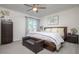Cozy bedroom with a ceiling fan, a large bed, a dresser, and a window providing natural light at 118 Wall St, Redington Shores, FL 33708