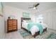 Bright bedroom featuring a bed with a turquoise throw, a stylish dresser, and natural light from the window at 118 Wall St, Redington Shores, FL 33708