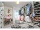 Spacious walk-in closet featuring custom shelving, a pink vanity desk and chair, and a decorative rug at 118 Wall St, Redington Shores, FL 33708