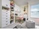 Organized walk-in closet with custom shelving, a desk and chair, drawers, and a comfortable ottoman at 118 Wall St, Redington Shores, FL 33708