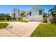 Beautifully landscaped home featuring a two-car garage, grassy yard, and a welcoming entrance with an American flag at 118 Wall St, Redington Shores, FL 33708
