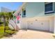 Exterior view of garage entrance with adjacent staircase and small garden with view of American Flag at 118 Wall St, Redington Shores, FL 33708