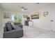 Modern living room with a comfortable sofa, a wall-mounted television, and a sliding glass door to outdoor area at 118 Wall St, Redington Shores, FL 33708