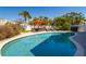 Inviting backyard pool area with lush landscaping, lounge chairs, and outdoor dining space at 118 Wall St, Redington Shores, FL 33708