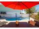 Inviting pool area featuring comfortable seating, a dining area, and an umbrella at 118 Wall St, Redington Shores, FL 33708