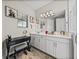 Bright bathroom with a makeup vanity, white cabinets, and a large mirror above the double sinks at 12808 Boggy Creek Dr, Riverview, FL 33579