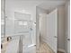 A sleek, tiled bathroom featuring a glass-enclosed shower with a window and a door to another room at 12808 Boggy Creek Dr, Riverview, FL 33579