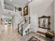 Spacious foyer with high ceilings, wood-look tile flooring, and staircase with decorative mirror at 12808 Boggy Creek Dr, Riverview, FL 33579