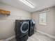 Convenient laundry room featuring modern washer and dryer, plus shelving and window for natural light at 12808 Boggy Creek Dr, Riverview, FL 33579