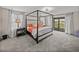 Spacious main bedroom features a canopy bed, large windows, and access to a private balcony at 12808 Boggy Creek Dr, Riverview, FL 33579