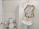 Charming powder room with ornate mirror, pedestal sink, and elegant fixtures at 12808 Boggy Creek Dr, Riverview, FL 33579