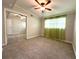 Bedroom features carpet, ceiling fan, a window with curtains, and a mirrored sliding-door closet at 133 15Th Nw St, Largo, FL 33770