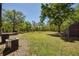 Large backyard with mature trees and lush greenery, a shed, and an air conditioning unit at 14114 N 301 Hwy, Thonotosassa, FL 33592