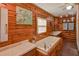 Inviting bathroom features a soaking tub, double vanity, and warm wood-paneled walls at 14114 N 301 Hwy, Thonotosassa, FL 33592