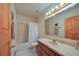 Traditional bathroom with shower-tub combo, neutral tile, and an oak vanity at 14114 N 301 Hwy, Thonotosassa, FL 33592