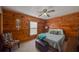 Cozy bedroom featuring wood paneling, ceiling fan and a comfortable queen-size bed at 14114 N 301 Hwy, Thonotosassa, FL 33592