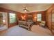Charming bedroom featuring wood walls, ceiling fan and a unique log-style bed frame at 14114 N 301 Hwy, Thonotosassa, FL 33592