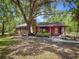 Charming log cabin featuring a stone chimney, a green door, and lovely landscaping at 14114 N 301 Hwy, Thonotosassa, FL 33592