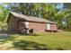 Exterior of the log cabin-style home with a small deck, window, and air conditioning unit in a green yard at 14114 N 301 Hwy, Thonotosassa, FL 33592