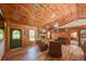 Inviting living room with wood-clad walls, stone fireplace, and comfortable leather seating at 14114 N 301 Hwy, Thonotosassa, FL 33592