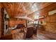 Open-concept living area featuring wood walls, stone fireplace, and seamless flow to the kitchen at 14114 N 301 Hwy, Thonotosassa, FL 33592