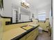 Retro-style bathroom with yellow tile, vintage fixtures, and ample counter space at 1542 Picardy Cir, Clearwater, FL 33755