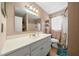 Bathroom with a long white vanity, shower and tub with a white curtain, and a small window at 1542 Picardy Cir, Clearwater, FL 33755