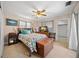 Comfortable bedroom featuring a ceiling fan, tiled floors, and natural light at 1542 Picardy Cir, Clearwater, FL 33755