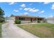 View of the exterior elevation featuring a driveway leading to an attached garage at 1542 Picardy Cir, Clearwater, FL 33755