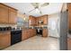 Well-lit kitchen boasting wood cabinets, tile floors, and stainless steel appliances at 1542 Picardy Cir, Clearwater, FL 33755