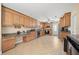 Spacious kitchen featuring wood cabinets, tile floors, and granite countertops at 1542 Picardy Cir, Clearwater, FL 33755