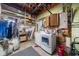 A functional laundry area with a washing machine, dryer, shelving, and storage cabinets at 1542 Picardy Cir, Clearwater, FL 33755