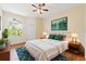 A well-lit bedroom features a ceiling fan, and a bed with decorative pillows, complemented by an area rug and large window at 17108 Carrington Park Dr # 711, Tampa, FL 33647