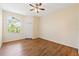 A serene bedroom featuring hardwood floors, a ceiling fan and ample natural light from the window at 17108 Carrington Park Dr # 711, Tampa, FL 33647