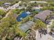 Aerial view of a community pond with fountain and tennis court, surrounded by lush greenery at 17108 Carrington Park Dr # 711, Tampa, FL 33647
