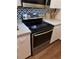 Close up of stainless steel range with black backsplash and white cabinets, with modern design touches at 17108 Carrington Park Dr # 711, Tampa, FL 33647