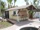 Charming pool house with an outdoor bar, seating, and tropical landscaping, perfect for entertaining by the pool at 1844 Venetian Point Dr, Clearwater, FL 33755