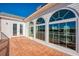 Balcony with decorative tile, white railing, three arched top windows and a set of french doors at 2829 Seabreeze S Dr, Gulfport, FL 33707